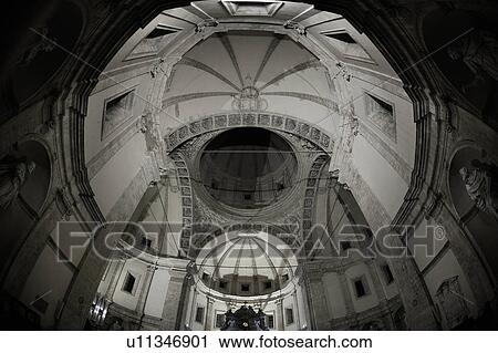 Stock Image - Interior of Santa Maria Maggiore, Rome, showing central nave, baldacchino over altar, coffered ceiling, rich Baroque decoration, and crypt below. Fotosearch
