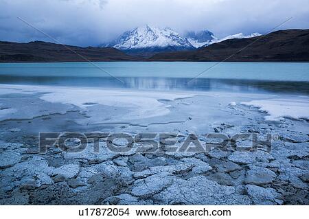Picture - Laguna Amarga at sunrise with view of Las Torres reflected in water, sulphur deposits along shoreline, Torres del Paine, Southern Chile, Patagonia. Fotosearch