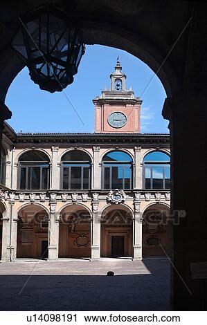 Stock Image - Loggia at entrance of Palazzo Archiginnasio, with view from under arch, of the two-tiered Renaissance buildings and central tower surrounding the courtyard, Bologna, Italy. Fotosearch