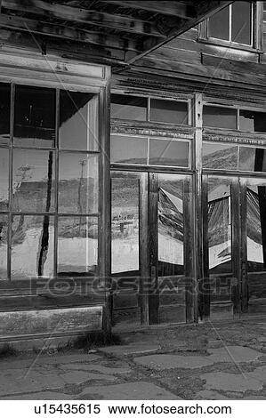 Main hotel doorway with glass abstract reflection of wooden housing, hills and sky in early summer morning, Bodie pioneer village, California View Large Photo Image Stock Photography - Main hotel doorway with glass abstract reflection of wooden housing, hills and sky in early summer morning, Bodie pioneer village, California. Fotosearch