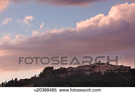 Stock Photography - Medieval hilltop town of Monte Castello di Vibio, at sunset, with spectacular pink clouds, skyscape, Umbria, Italy. Fotosearch