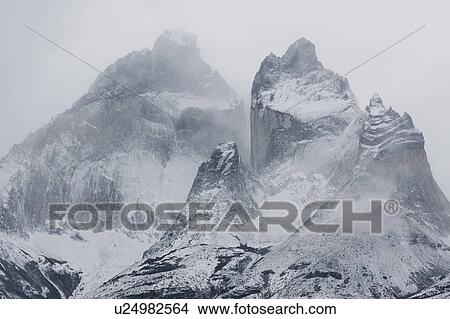 Picture - Panorama monochrome view of snow covered Los Cuernos mountains with dramatic autumn cloudscape, Torres del Paine, Southern Chile, Patagonia. Fotosearch