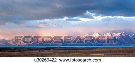 Stock Image - Panorama view of sunrise over the Andes mountain range, El Chalten, Argentina, Patagonia, with stunning pink and blue skyscape.. Fotosearch
