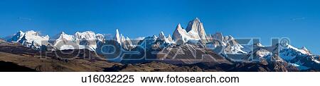 Stock Photography - Panorama view of sunrise over the snow covered Andes mountain range, El Chalten, Argentina, Patagonia, with clear blue sky, and mountains of Mount Fitzroy and Cerro Torre. Fotosearch