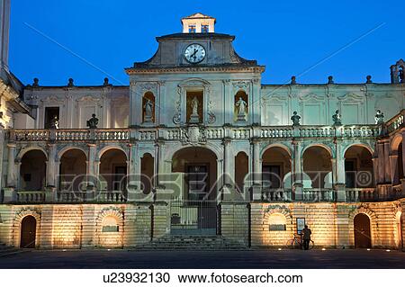 Piazza del Duomo, with view of Baroque ornamentation of Palazzo Vescovile (Bishop's Palace), dusk with night illumination, single male figure beside bicycle, Lecce, Salento, Puglia, Southern Italy View Large Photo Image Stock Image - Piazza del Duomo, with view of Baroque ornamentation of Palazzo Vescovile (Bishop's Palace), dusk with night illumination, single male figure beside bicycle, Lecce, Salento, Puglia, Southern Italy. Fotosearch