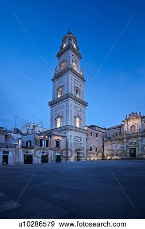 Stock Photo - Piazza del Duomo, with view of campanile (bell tower) and Baroque ornamentation of Cathedral, dusk with night illumination, Lecce, Salento, Puglia, Southern Italy. Fotosearch