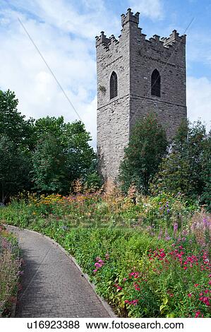 Romanesque square tower of St. Auden's Church on sunny summer afternoon, path through colourful flowerbeds, blue sky, Dublin, Southern Ireland View Large Photo Image Stock Photo - Romanesque square tower of St. Auden's Church on sunny summer afternoon, path through colourful flowerbeds, blue sky, Dublin, Southern Ireland. Fotosearch