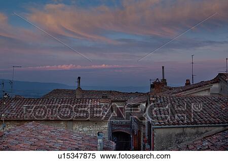 Rooftop view of Italian village street with houses and roof tiles in foreground and spectacular sunset, and hills beyond, Umbria, Italy View Large Photo Image Stock Photography - Rooftop view of Italian village street with houses and roof tiles in foreground and spectacular sunset, and hills beyond, Umbria, Italy. Fotosearch