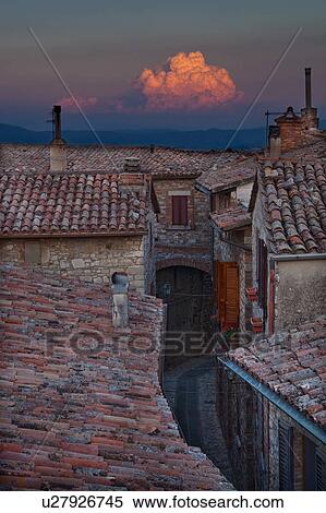 Rooftop view of Italian village street with houses and roof tiles in foreground, and spectacular sunset and hills beyond, Umbria, Italy View Large Photo Image Stock Photography - Rooftop view of Italian village street with houses and roof tiles in foreground, and spectacular sunset and hills beyond, Umbria, Italy. Fotosearch