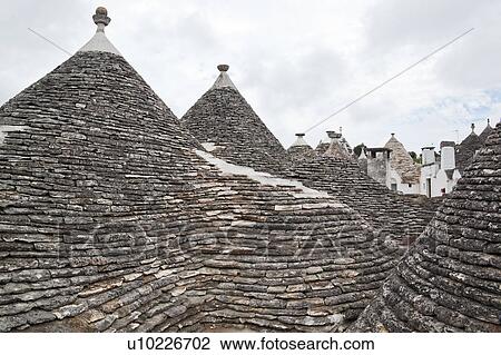 Rooftop view: town of Alberobello, World Heritage site, with trullo houses, white painted stone with piled stone conical roofs and large chimneys, monochrome view, Puglia, Southern Italy View Large Photo Image Stock Image - Rooftop view: town of Alberobello, World Heritage site, with trullo houses, white painted stone with piled stone conical roofs and large chimneys, monochrome view, Puglia, Southern Italy. Fotosearch