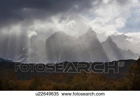 Snow covered Los Cuernos mountains with godbeams and dramatic autumn cloudscape, fall colours of trees in foreground, Torres del Paine, Southern Chile, Patagonia View Large Photo Image Stock Photography - Snow covered Los Cuernos mountains with godbeams and dramatic autumn cloudscape, fall colours of trees in foreground, Torres del Paine, Southern Chile, Patagonia. Fotosearch