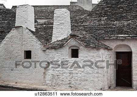 Street view: town of Alberobello, World Heritage site, with trullo house, white painted stone with piled stone conical roofs with large chimneys, monochrome view, Puglia, Southern Italy, View Large Photo Image Stock Image - Street view: town of Alberobello, World Heritage site, with trullo house, white painted stone with piled stone conical roofs with large chimneys, monochrome view, Puglia, Southern Italy,. Fotosearch