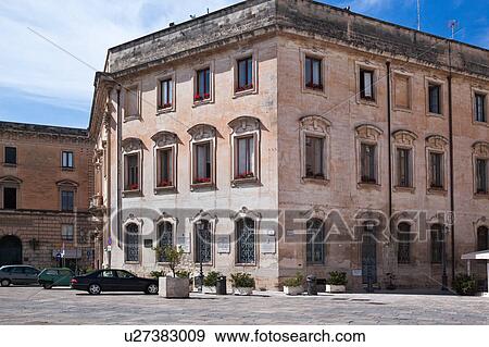 Typical Renaissance palazzo, in pink stone, decorated windows, red flowers on each sill, view of paved piazza, sunny spring morning with blue sky, Lecce, Salento, Puglia, Southern Italy View Large Photo Image Stock Photo - Typical Renaissance palazzo, in pink stone, decorated windows, red flowers on each sill, view of paved piazza, sunny spring morning with blue sky, Lecce, Salento, Puglia, Southern Italy. Fotosearch