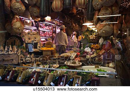 Stock Image - Typical window display of delicatessen shop with display of local produce of meat, cheese, wines for sale, Bologna, Italy. Fotosearch