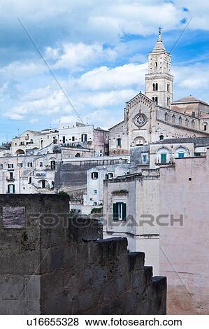 Stock Photo - View of ancient town of Matera with tufa houses, and Duomo on hill, sunny spring afternoon with blue sky, Puglia, Southern Italy,. Fotosearch