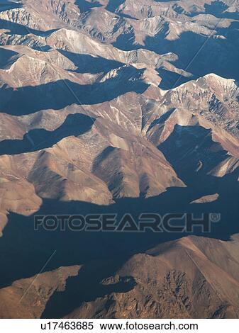 Stock Photography - View of Cordillera range of mountains from aeroplane, with texture effect of sun and shadow, Santiago, Chile. Fotosearch