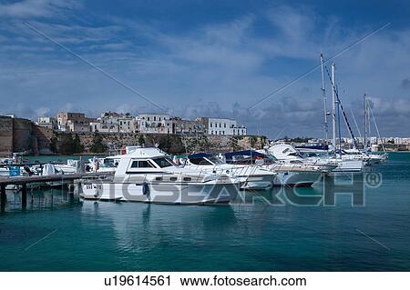 View of Otranto harbour with moored sailboats and motorboats, medieval fortifications and town beyond, sunny spring morning with blue sky, Salento, Puglia, Southern Italy View Large Photo Image Stock Image - View of Otranto harbour with moored sailboats and motorboats, medieval fortifications and town beyond, sunny spring morning with blue sky, Salento, Puglia, Southern Italy. Fotosearch