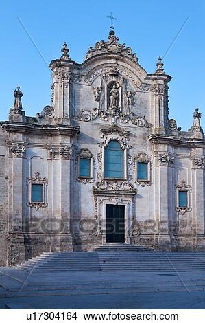 Picture - View of piazza and stairs leading to Baroque facade of San Francesco, with typical stone carved scroll work and statues, decorated doorway, sunny spring evening, Matera, Puglia, Southern Italy. Fotosearch