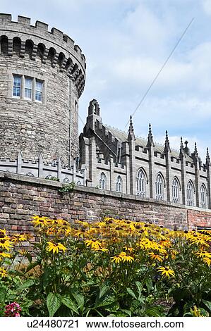 Stock Image - View of Record Tower and Chapel, South side of Dublin Castle with bright yellow coreopsis in full bloom in Garda memorial garden, on sunny summer morning, Dublin, Southern Ireland. Fotosearch