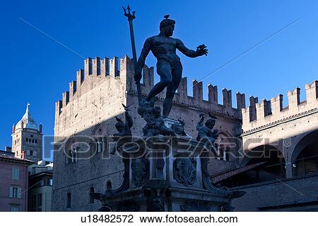 Stock Image - View of Statue of Neptune, Piazza Maggiore with merloned fortifications of Palazzo del Popolo beyond, sunny summer late afternoon, Bologna, Italy. Fotosearch