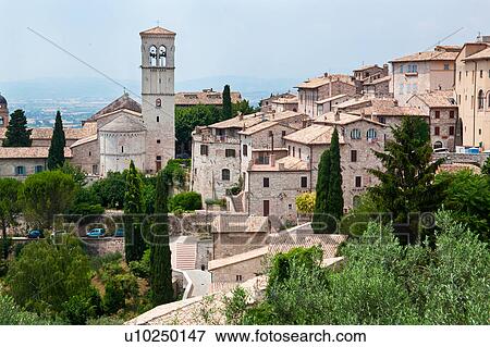Stock Photo - View overlooking town, showing red-tiled rooftops, medieval stone houses, church and square campanile belltower of Assisi, Umbria, Italy. Fotosearch