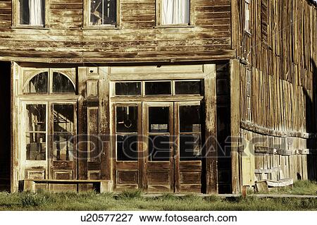 Stock Photo - Wooden buildng, detail of doorway and windows, on main street, lit in dawn light, desaturated image, Bodie pioneer village, California. Fotosearch
