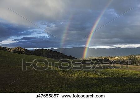 Stock Photo - Oak View, California, USA, March 1, 2015, full rainbow over rain storm in Ojai Valley. Fotosearch