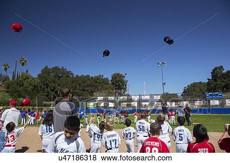 Stock Photo - Oak View, California, USA, March 7, 2015, Ojai Valley Little League Field, youth Baseball, Spring, hats tossed in air. Fotosearch