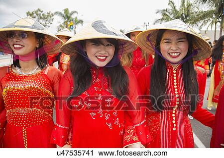 Stock Image - Orange County, City of Westminster, Southern California, USA, February 21, 2015, Little Saigon, Vietnamese-American Community, TET Parade celebrates Tet Lunar New Year, women in cultural red dresses. Fotosearch