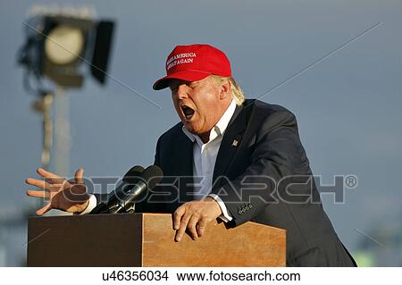 Picture - SAN PEDRO, CA - SEPTEMBER 15, 2015: Donald Trump, 2016 Republican presidential candidate, speaks during a rally aboard the Battleship USS Iowa in San Pedro, Los Angeles, California while wearing a red baseball hat that says campaign slogan "Make.... Fotosearch