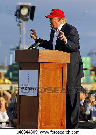 Stock Photo - SAN PEDRO, CA - SEPTEMBER 15, 2015: Donald Trump, 2016 Republican presidential candidate, speaks during a rally aboard the Battleship USS Iowa in San Pedro, Los Angeles, California while wearing a red baseball hat that says campaign slogan "Make.... Fotosearch