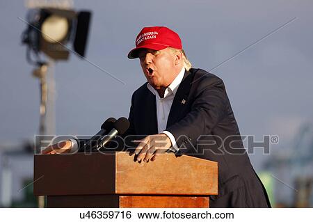 Stock Photograph - SAN PEDRO, CA - SEPTEMBER 15, 2015: Donald Trump, 2016 Republican presidential candidate, speaks during a rally aboard the Battleship USS Iowa in San Pedro, Los Angeles, California while wearing a red baseball hat that says campaign slogan "Make.... Fotosearch