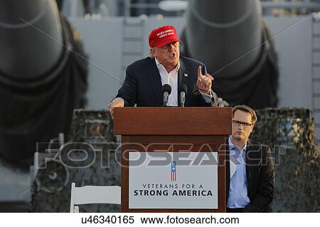 Stock Photography - SAN PEDRO, CA - SEPTEMBER 15, 2015: Donald Trump, 2016 Republican presidential candidate, speaks under large battleship guns during a rally aboard the Battleship USS Iowa in San Pedro, Los Angeles, California.. Fotosearch