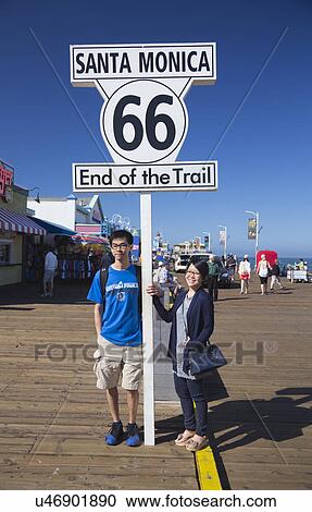 Santa Monica, California, USA 5/2/2015, asian couple pose at Route 66 sign Santa Monica Pier, end of famous Route 66 highway from Chicago View Large Photo Image Stock Image - Santa Monica, California, USA 5/2/2015, asian couple pose at Route 66 sign Santa Monica Pier, end of famous Route 66 highway from Chicago. Fotosearch