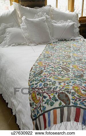 Stock Image - Bed runner and throw pillows on bed. Fotosearch
