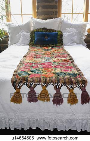 Stock Photography - Bed runner and throw pillows on bed. Fotosearch
