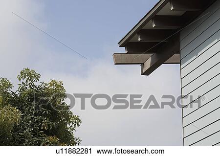 Stock Image - Blue sided house against blue sky. Fotosearch