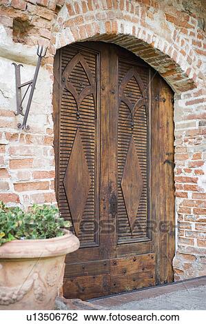 Stock Image - Brick building with large wooden double doors. Fotosearch