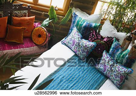 Stock Photograph - Colorful bed runner and pillows on bed. Fotosearch