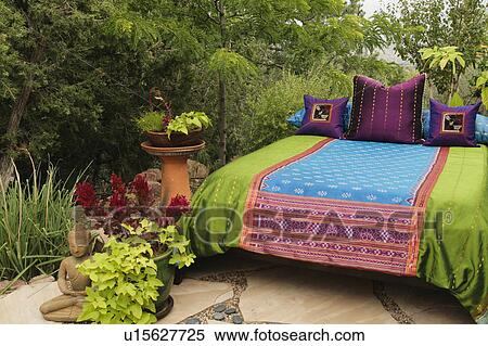 Stock Photography - Colorful bedding on outdoor bed. Fotosearch