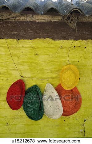 Colorful hats hanging against bright yellow wall View Large Photo Image Stock Photo - Colorful hats hanging against bright yellow wall. Fotosearch