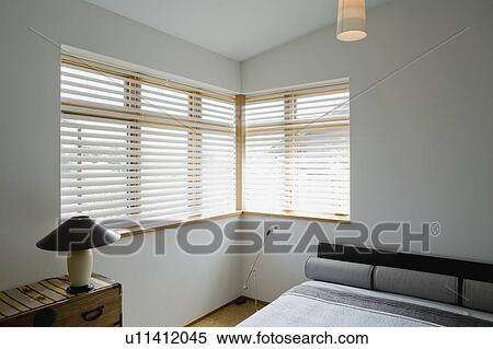 Contemporary bedroom with gray bed and corner windows View Large Photo Image Stock Photography - Contemporary bedroom with gray bed and corner windows. Fotosearch