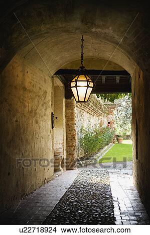 Picture - Covered stone driveway with hanging light. Fotosearch