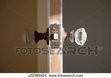 Picture - Detail glass doorknob in wooden door. Fotosearch