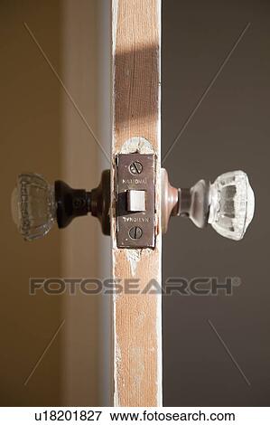 Stock Photo - Detail glass doorknob in wooden door. Fotosearch
