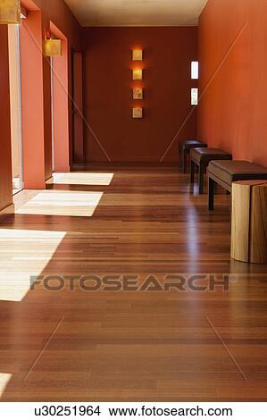 Picture - Hardwood floor in hallway with doorways and benches. Fotosearch