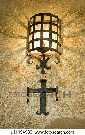 Stock Photograph - Illuminated light with wrought iron covering. Fotosearch