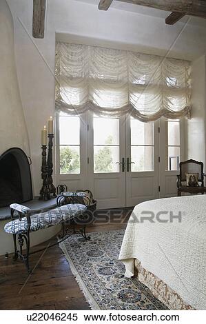 Stock Photography - Kiva fireplace in corner of bedroom. Fotosearch