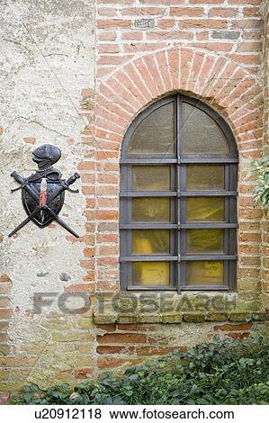 Stock Photo - Knight emblem on exterior wall next to window. Fotosearch