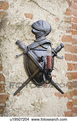 Picture - Knight emblem on wall with light. Fotosearch